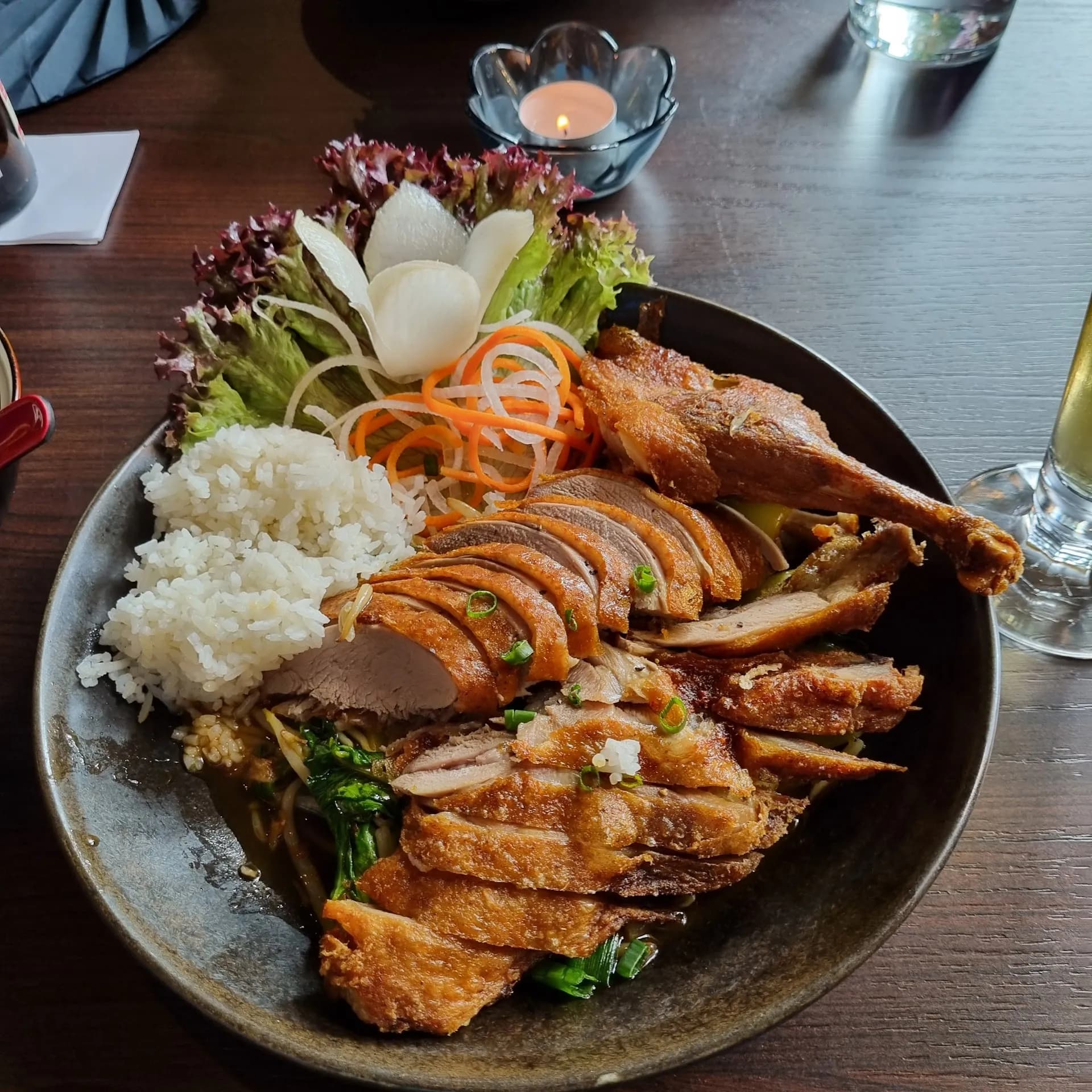 Enten-Platte mit Reis und Salat bei Kerzenschein